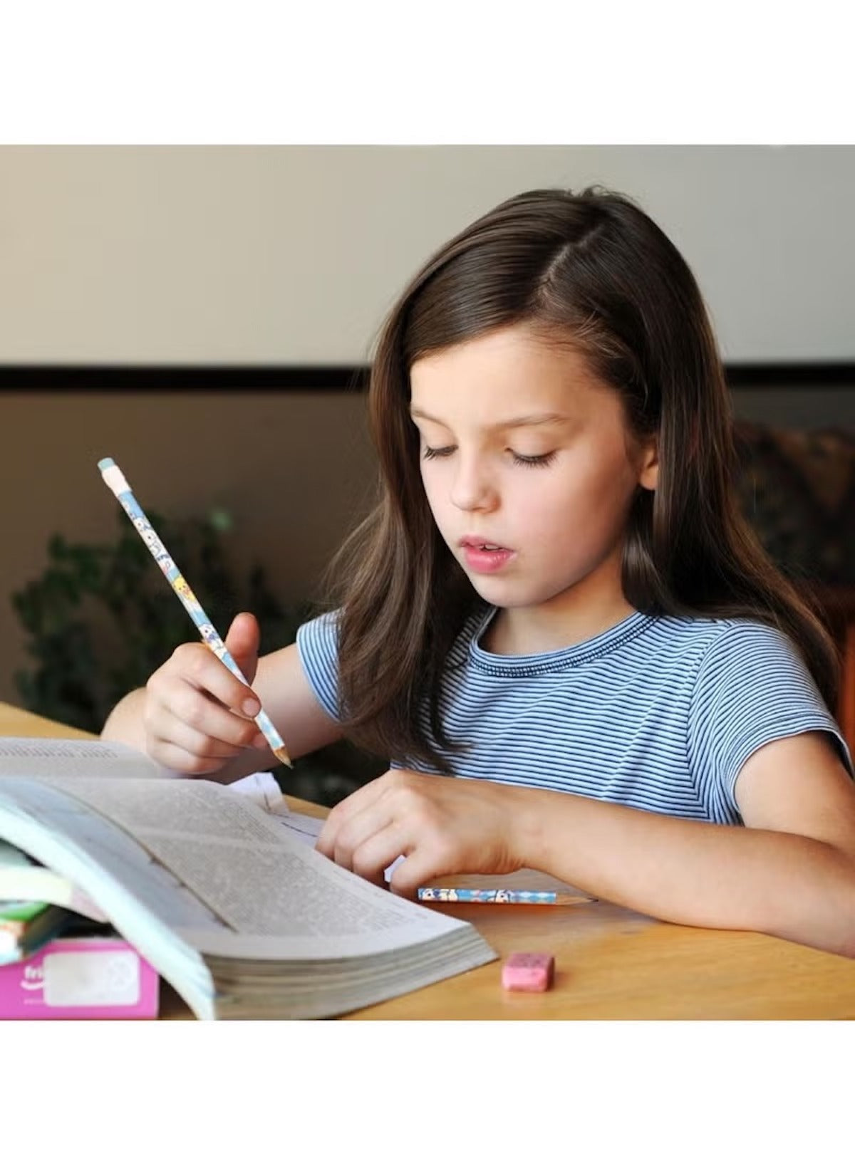 Child using a Sanrio pencil set with accessories while studying at a desk