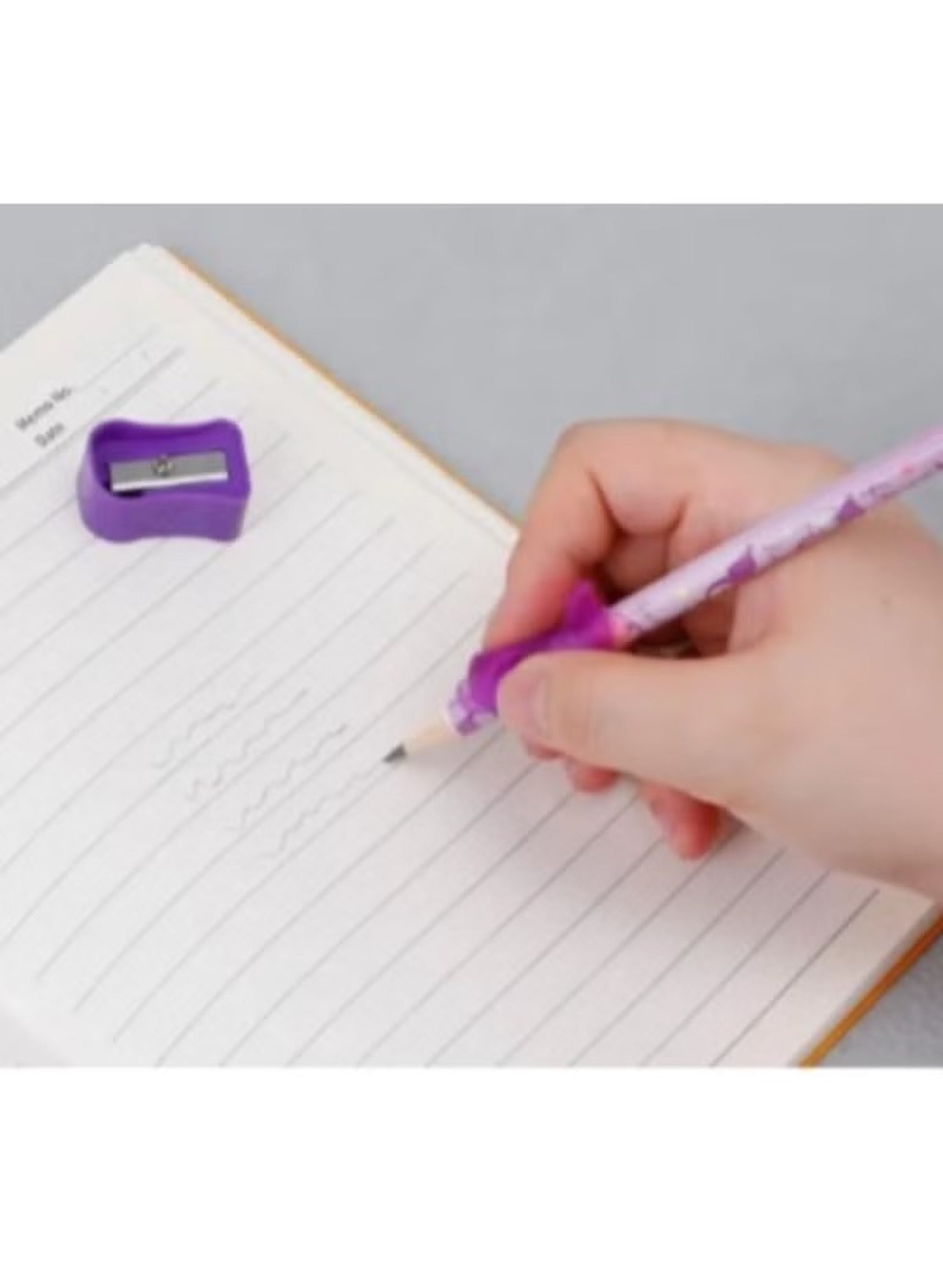 Person using a Sanrio pencil set with accessories on a notebook with a purple sharpener