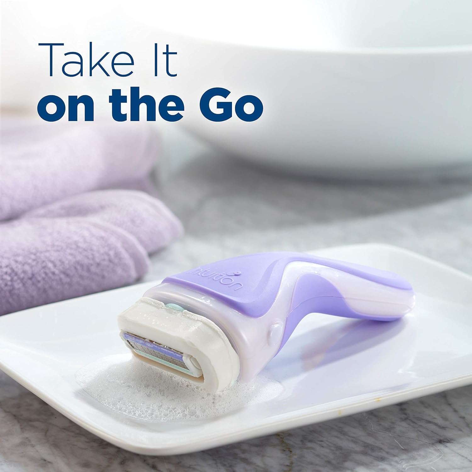 Lavender Schick Intuition razor on soap dish with suds and towel by sink Schick Intuition razor refill cartridges