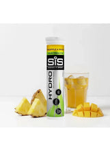 SiS Hydro electrolyte tablet tube, pineapple & mango flavor, next to cut pineapple and glass