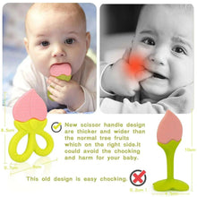 Baby with pink and green silicone fruit teether in mouth