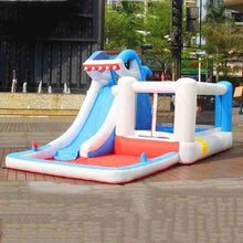 Inflatable shark-themed water slide with blue body, white rails, and red base on patio
