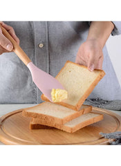 Person spreading butter on bread using a silicone spatula from the 19 piece kitchen tool set UAE by Huitich