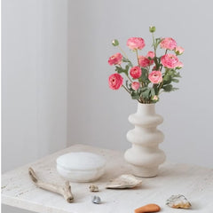 Huitich silk rose flower bouquet with pink artificial flowers in a white sculpted vase on a stone table