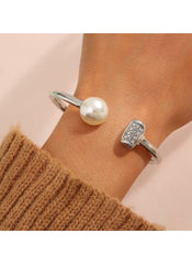 Huitich silver cuff bracelet with pearl and crystal accents on wrist with brown sweater