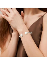 Silver cuff bracelet with two crystal-set square sections and a white pearl front