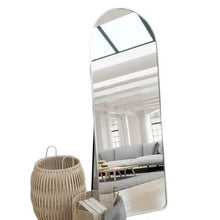 Arched full-length standing mirror with silver frame, angled reflection