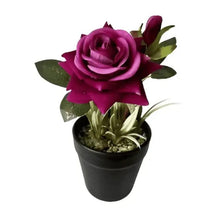 Purple artificial rose plant in matte black pot with green leaves