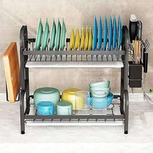 Black kitchen dish rack with plate supports and side utensil holders, holding cups and bowls