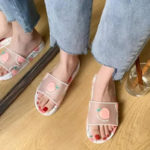 Peach-printed white slides with open toe and thin front strap on feet