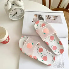 White slides with peach fruit print, open toe, and thin adjustable strap