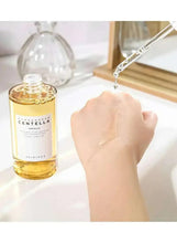 Centella ampoule serum bottle with dropper dispensing amber liquid onto skin
