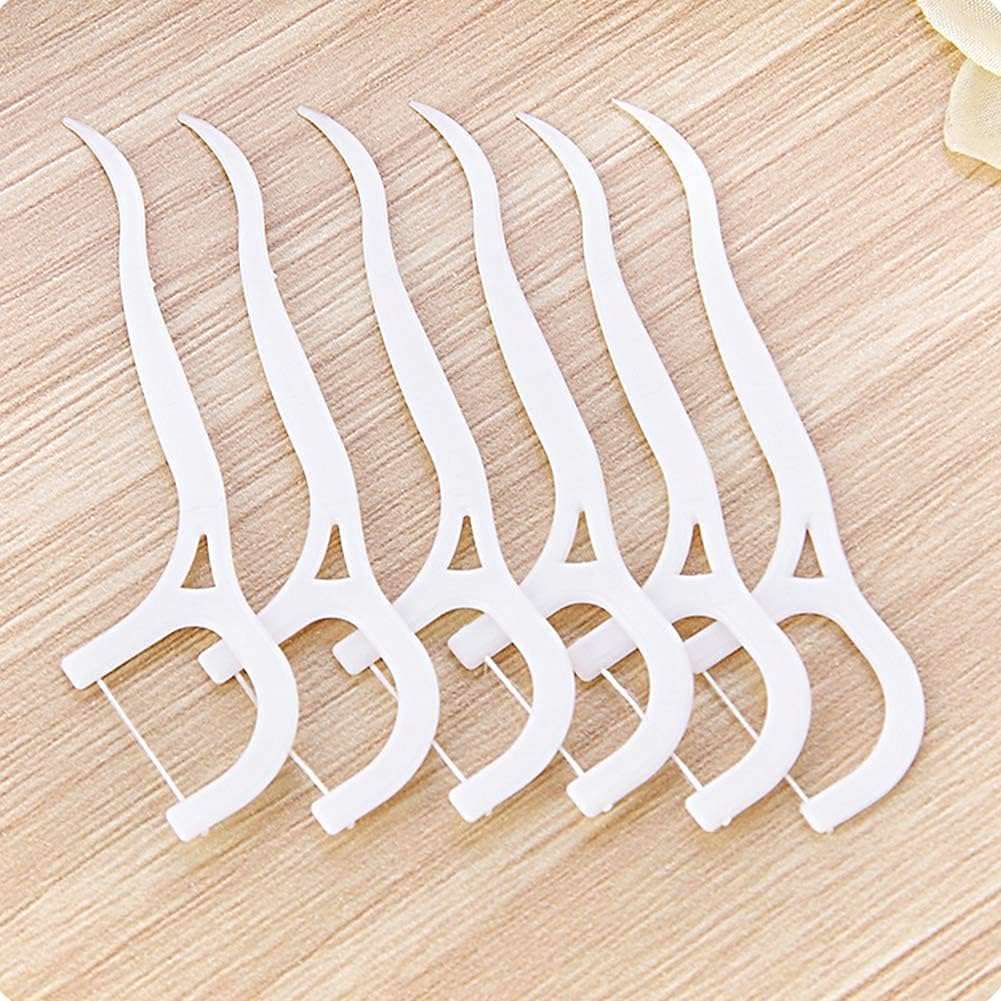Beibi white plastic dental floss picks 160 pcs. fanned on a wooden surface for daily oral care