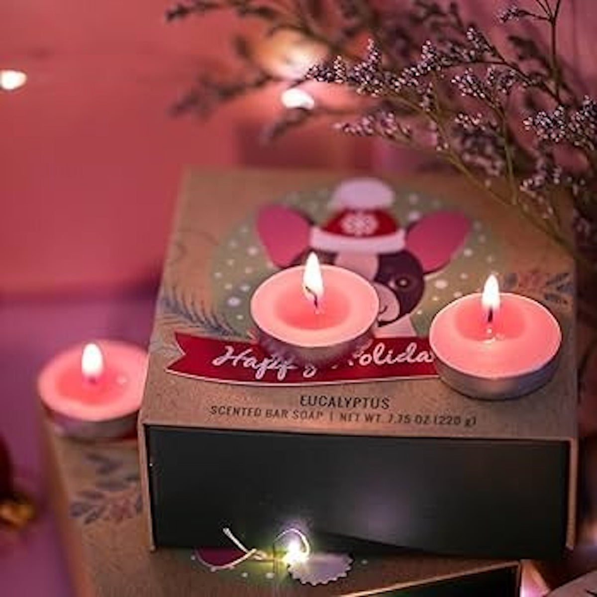 Huitich smokeless tea light candles glowing pink on holiday-themed packaging with floral background