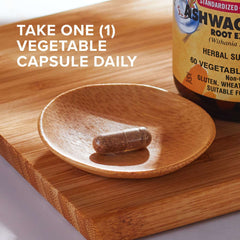 Solgar bottle and single vegetable capsule on wooden dish with instruction text showing ashwagandha root extract capsules