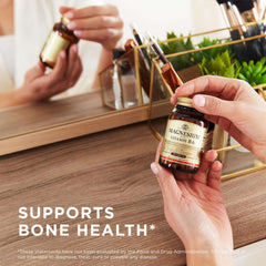 Hands holding Solgar Magnesium with Vitamin B6 tablets bottle by vanity mirror supporting bone health
