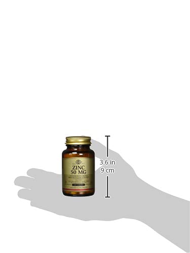 Solgar zinc tablets 50mg amber glass bottle of 50 MG zinc supplement shown on hand for size reference