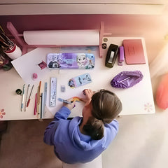 Space-themed writing kit for children on a desk with stationery and a child drawing