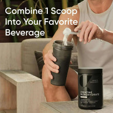 Creatine monohydrate tub with white scoop powder being poured into a shaker cup
