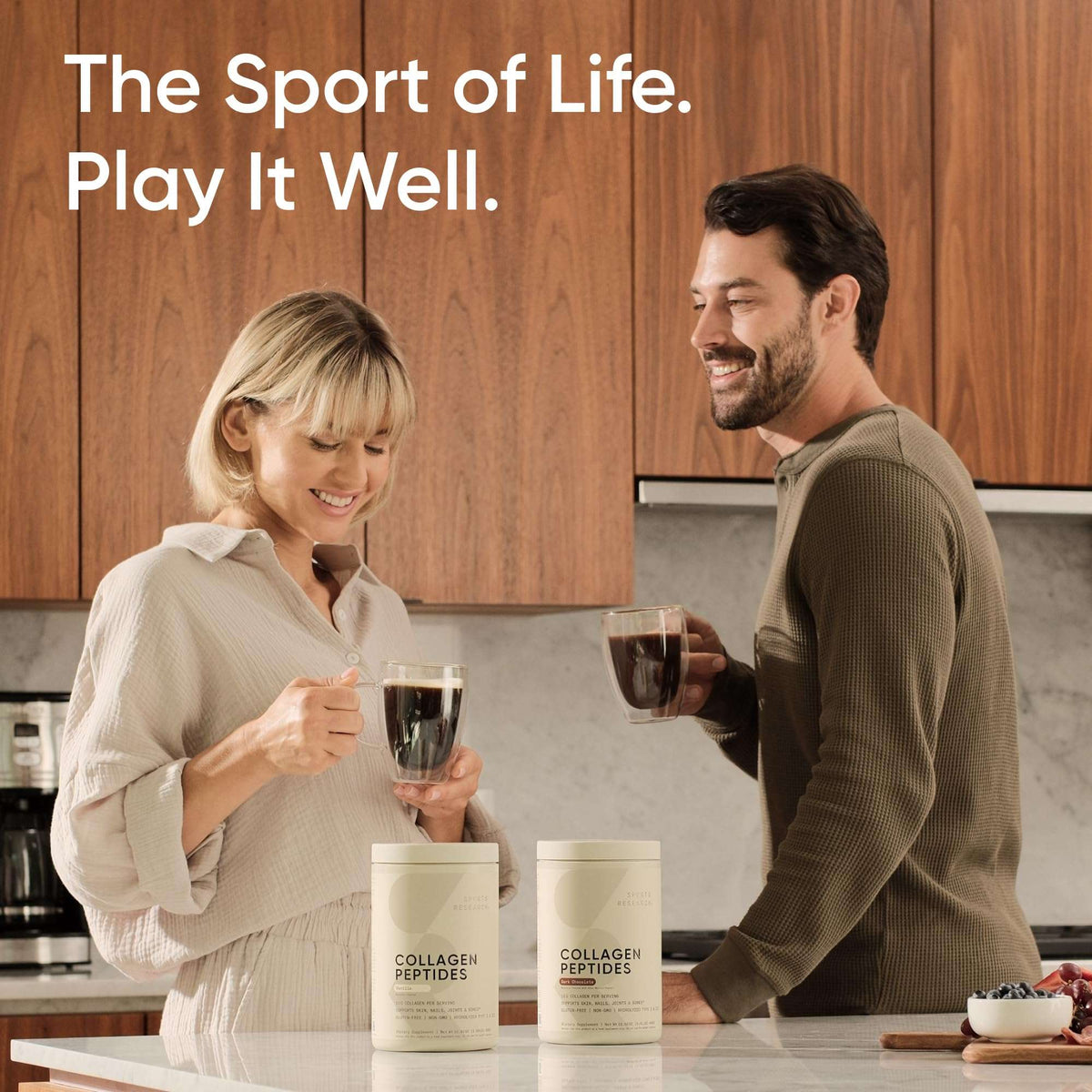 Couple enjoying coffee in a kitchen with two tubs of grass-fed collagen peptides powder on the counter