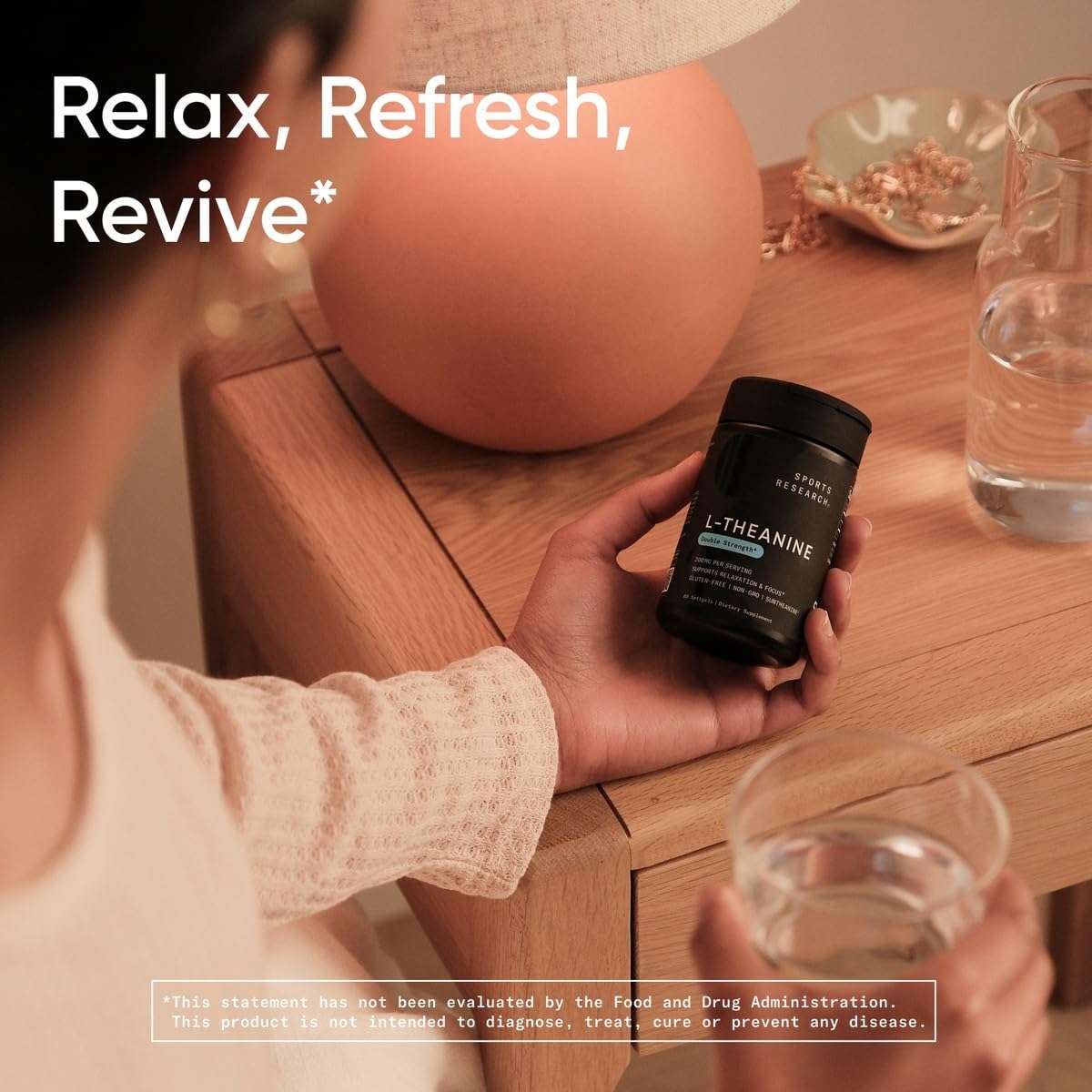 Woman holding Sports Research L-theanine softgels bottle by bedside with glass of water and lamp
