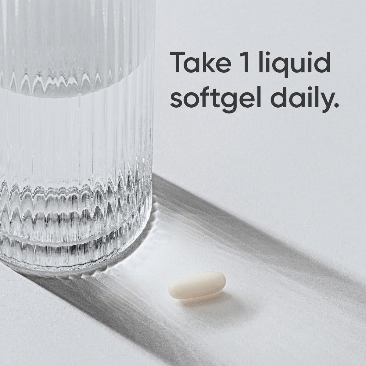 Sports Research L-theanine softgels single liquid softgel next to a ribbed glass with dosage text
