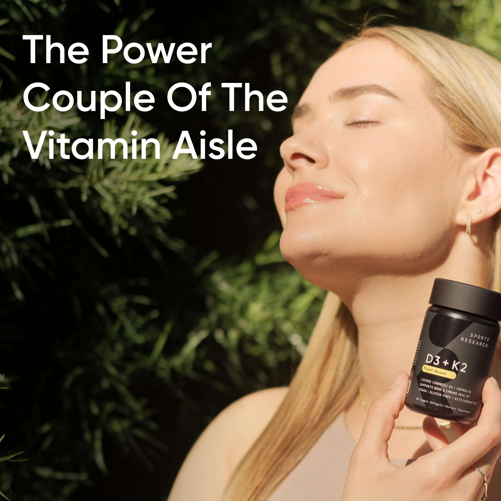 Woman basking in sun holding Sports Research D3 and K2 supplement bottle for bone health Vitamin K2 D3 supplement UAE