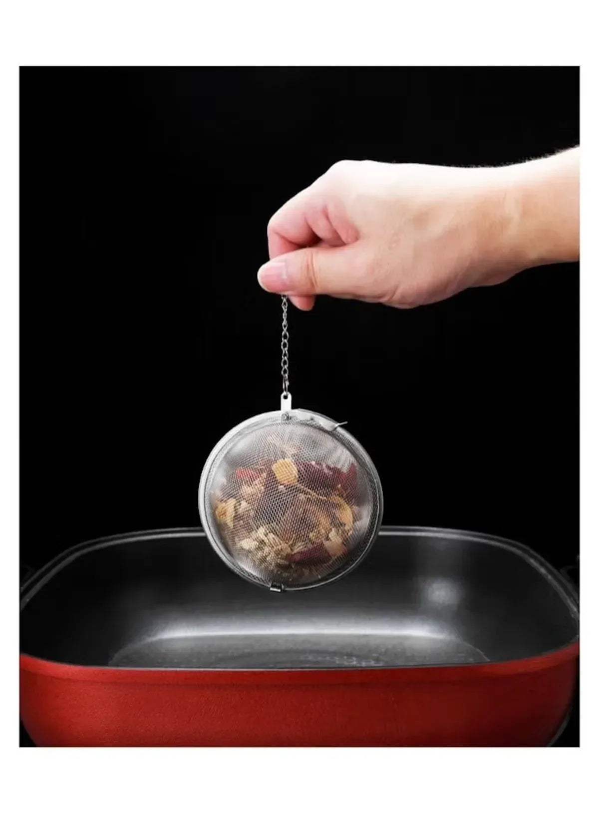 stainless-steel-tea-infuser-ball-dipping-into-pot -- Mumzar