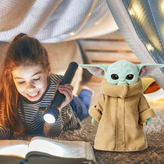 11 inch Baby Yoda plush toy by Huitich next to a girl reading a book under a blanket fort with a flashlight