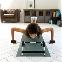 Steel push-up bars set with black grips positioned under hands on mat