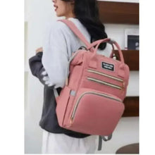 Pink baby travel backpack, side view, front zips, padded shoulder straps