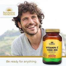Vitamin C 1000 mg bottle with rose hips label held in front of smiling man