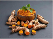 Turmeric powder bowl with scattered turmeric roots and orange slices