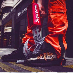Huitich handheld money gun toy for kids shooting fake bills with person wearing orange pants and black sneakers
