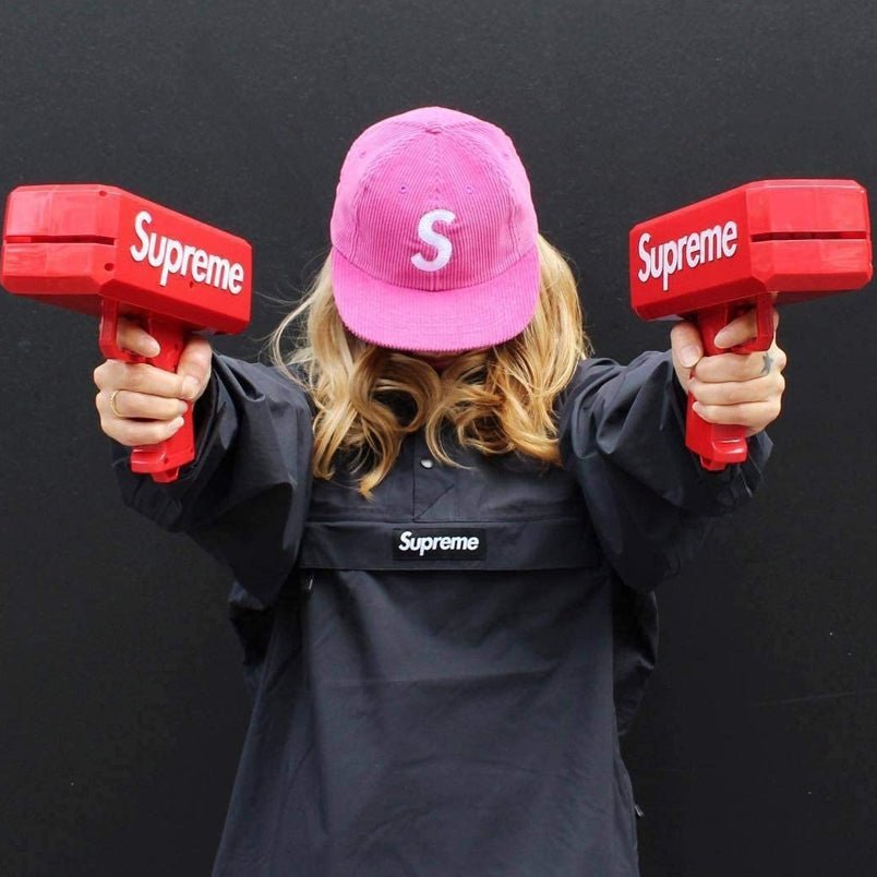 Huitich handheld money gun toy for kids in red held by person wearing black and pink cap