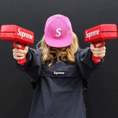 Huitich handheld money gun toy for kids in red held by person wearing black and pink cap