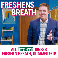 Man winking and pointing in a colorful bathroom ad for TheraBreath oral rinse for bad breath. Freshens Breath signage