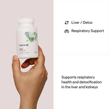 Hand holding NAC supplement bottle with Liver/Detox and Respiratory Support icons