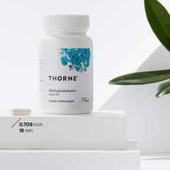 Thorne Methylcobalamin supplement bottle and capsule on white display with green leaf Vitamin B12 supplement UAE
