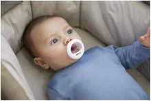 Tommee Tippee breast-like soother on baby in light blue pajamas, white shield
