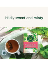 Herbal pregnancy tea bag package with mug of tea and fresh green leaves