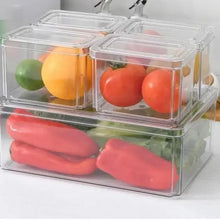 Clear multi-compartment refrigerator organizer box with sliced vegetables and fruit inside