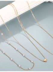 Triple layer pearl choker necklace by Mumzar featuring delicate gold chains and pearl accents