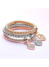 Triple-tone heart charm bracelet with three beaded bangles and five glitter heart pendants, rose