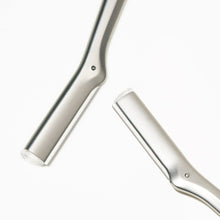 Silver facial razor dermaplaner tool with curved handle and blade edge