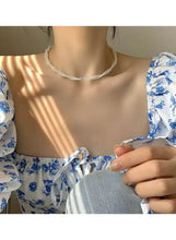 Faux pearl choker necklace worn on model, twisted strand with small pearl beads