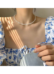 Elegant twisted faux pearl choker necklace worn with a floral blouse for a chic look