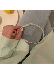 Twisted faux pearl choker necklace by Huitich worn with a mint green shirt and denim jeans