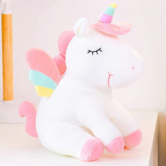 Huitich unicorn plush toy for kids in white with pink and pastel rainbow details sitting on a white surface