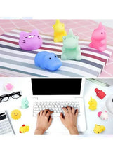 Pastel squishy animal toys on a striped mat and laptop desk
